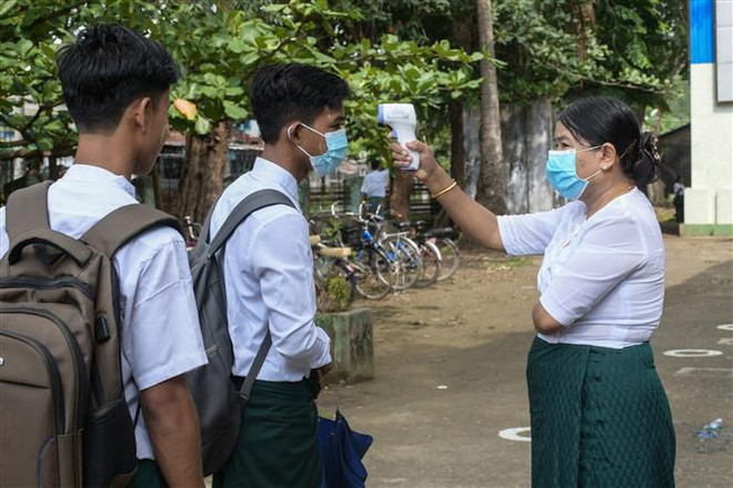 Kiểm tra thân nhiệt cho học sinh để phòng dịch COVID-19 tại trường học ở Sittwe, bang Rakhine, Myanmar. (Ảnh: AFP/TTXVN) Nhật Bản ủng hộ nỗ lực của ASEAN trong giải quyết vấn đề Myanmar ảnh 1