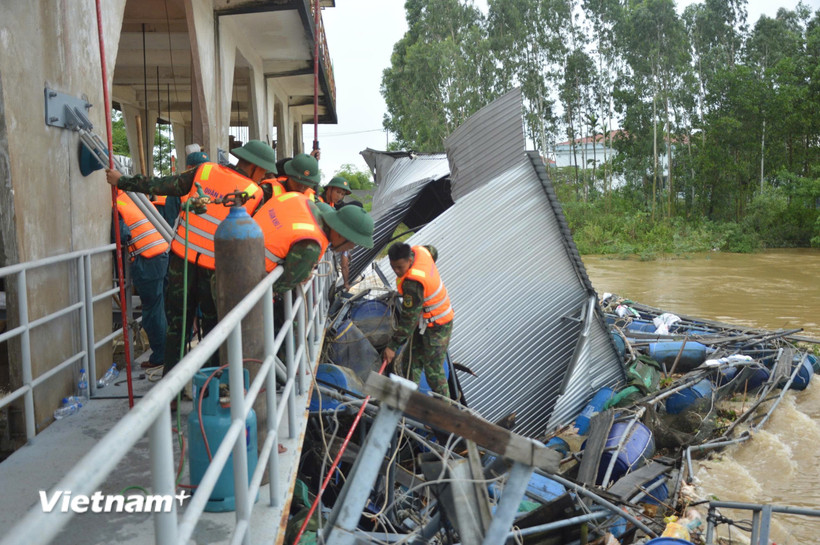Lực lượng Bộ Chỉ huy quân sự thành phố Đà Nẵng khẩn trương xử lý các lồng bè trôi dạt bị mắc tại thân đập An Trạch. (Ảnh: Quang Cường)