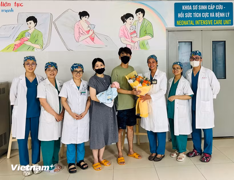 Cán bộ y, bác sỹ bệnh viện Phụ sản - Nhi Đà Nẵng chúc mừng gia đình du khách. (Ảnh: PV/Vietnam+)