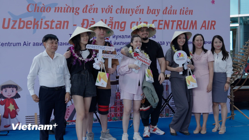 Ngành du lịch thành phố Đà Nẵng chụp hình lưu niệm với nhóm du khách đầu tiên trên chuyến bay từ Tashkent, Uzbekistan đến Đà Nẵng. (Ảnh: Thanh Phong/Vietnam+)
