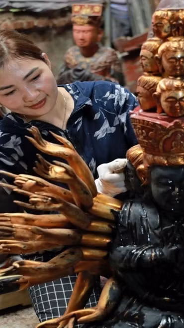 Nghệ nhân làng nghề Sơn Đồng hoàn thiện sản phẩm. (Ảnh: TTXVN phát)