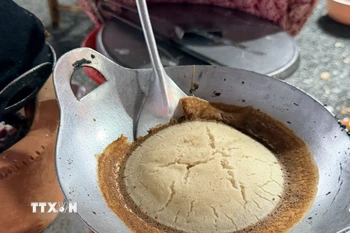 Bánh được nướng trên khuôn gang truyền thống, tỏa hương thơm hấp dẫn. (Ảnh: Thanh Sang/TTXVN)