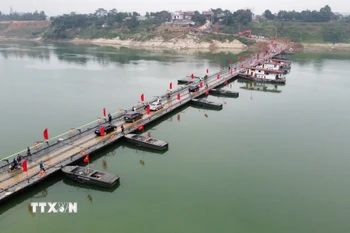 Người và phương tiện lưu thông bình thường qua cầu phao sông Lô sáng 16/2. (Ảnh: Nguyễn Văn Cảnh/TTXVN)