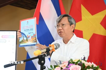Đại sứ Việt Nam tại Cuba Lê Quang Long giới thiệu với bạn bè Cuba ấn phẩm đặc biệt “Việt Nam-Cuba: 65 năm tình anh em.” (Ảnh: Việt Hùng/TTXVN)