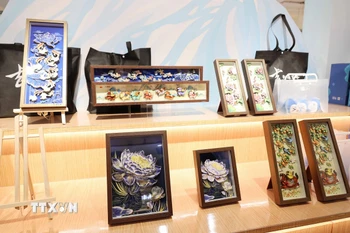 Du khách tìm hiểu về nghệ thuật chế tác tranh da cá của tỉnh Cát Lâm. (Ảnh: Công Tuyên/TTXVN)