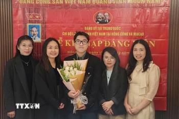 Nguyễn Thị Xuân Huệ (thứ hai, bên trái), nghiên cứu sinh chuyên ngành Ngôn ngữ học ứng dụng tiếng Anh tại Đại học Macau (Trung Quốc), Bí thư Chi bộ Lưu học sinh Việt Nam tại Hong Kong và Macau tại lễ kết nạp đảng viên mới. (Nguồn: TTXVN phát)
