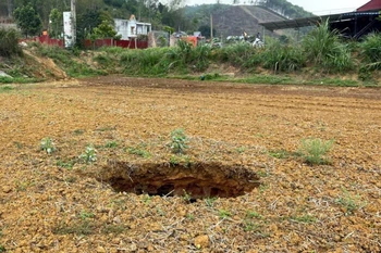 Hố sụt mới xuất hiện sáng ngày 11/4, cách vị trí hố sụt tại Km80+050 quốc lộ 3B chỉ khoảng 50m. (Ảnh: Nguyễn Công Hải/TTXVN)