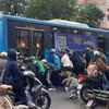 Hơn chục người nâng xe buýt để cứu nữ tài xế xe máy mắc kẹt tại Hà Nội