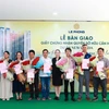 Đại diện Tập đoàn Lê Phong trao giấy chứng nhận quyền sở hữu căn hộ và hoa cho cư dân.