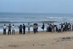 Nhiều người đổ ra bờ biển Vinh Thanh ngóng tìm nam sinh lớp 7 mất tích do sóng cuốn. (Nguồn: báo Tiền phong)