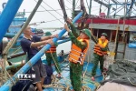 Lực lượng Đồn Biên phòng Quỳnh Phương (Bộ đội biên phòng tỉnh Nghệ An) hỗ trợ ngư dân chằng buộc trên tàu đánh cá trước cảnh báo bão, ngày 21/7/2025. (Ảnh: TTXVN phát)