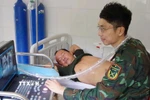 Bác sỹ Trung tâm y tế thị trấn Trường Sa siêu âm ổ bụng cho bệnh nhân Võ Sỹ Danh. (Ảnh: TTXVN phát)