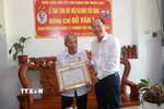 Bí thư Tỉnh ủy Cà Mau Nguyễn Hồ Hải trao Huy hiệu 65 năm tuổi Đảng cho đồng chí Đỗ Văn Ba. (Ảnh: Huỳnh Anh/TTXVN)