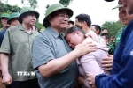 Thủ tướng Phạm Minh Chính động viên gia đình có người chết do mưa lũ ở xã Xa Dung. (Ảnh: Dương Giang/TTXVN)