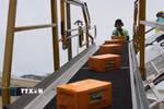 Vận chuyển hàng cứu trợ từ máy bay xuống sân bay quốc tế ở thủ đô Caracas. (Ảnh: Phi Hùng/TTXVN)