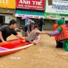 Sử dụng thuyền kayak đưa người dân vùng ngập lụt bị cô lập đến nơi an toàn. (Ảnh: Phan Sáu/TTXVN)