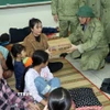Chủ tịch Ủy ban Nhân dân tỉnh Quảng Ngãi Nguyễn Hoàng Giang thăm, tặng quà ở điểm tập kết người dân tránh bão số 13 tại Trường Tiểu học, Trung học cơ sở Đức Lợi. (Ảnh: Cao Nguyên/TTXVN)