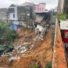 Phần móng của nhiều ngôi nhà cao tầng có nguy cơ tiếp tục sạt lở xuống vực sâu. (Ảnh: TTXVN phát)