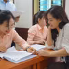 Người dân kiểm tra thông tin được ghi trong Giấy chứng nhận quyền sử dụng đất. (Ảnh: Kim Anh/TTXVN)