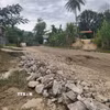 Người dân hàng ngày phải đi qua tuyến đường đầy bùn đất, đá hộc. (Ảnh: Quốc Dũng/TTXVN)