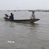 Việc đi lại giữa xã Quảng Điền và phường Kim Trà, thành phố Huế phải dùng thuyền, do lũ sông Bồ dâng cao gây ngập lụt ngày 17/11. (Ảnh: Nguyên Lý/TTXVN)