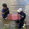 Lực lượng chức năng tìm thấy thi thể 2 em nhỏ đuối nước ở hồ Bến Sanh. (Ảnh: TTXVN phát)