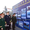 Đại tướng Phan Văn Giang và Thượng tướng Đổng Quân xem một số hình ảnh về 20 năm tuần tra liên hợp trên vùng biển Vịnh Bắc bộ giữa Hải quân hai nước. (Ảnh: Trọng Đức/TTXVN)