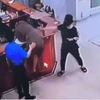 Hình ảnh người đàn ông chồm qua quầy làm thủ tục để hành hung nhân viên y tế. (Ảnh cắt từ clip)