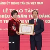 Bà Vũ Việt Trang, Ủy viên Ban Chấp hành Đảng bộ Khối các cơ quan Trung ương, Bí thư Đảng ủy, Tổng Giám đốc Thông tấn xã Việt Nam trao Huy hiệu 40 năm tuổi Đảng cho ông Thân Văn Hạnh. (Ảnh: Phương Hoa/TTXVN)