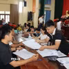 Người dân nhận tiền bồi thường giải phóng mặt bằng Cảng hàng không quốc tế Gia Bình. (Ảnh: Thanh Thương/TTXVN)