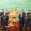 Tổng Bí thư Tô Lâm tặng hoa chúc mừng đội ngũ giáo sư, bác sỹ Bệnh viện Trung ương Quân đội 108. (Ảnh: Thống Nhất/TTXVN)