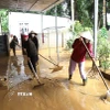 Người dân Nghệ An vệ sinh khắc phục hậu quả lũ lụt để sớm ổn định cuộc sống, sinh hoạt. (Ảnh: Xuân Tiến/TTXVN)