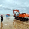 Lực lượng chức năng tỉnh Quảng Trị huy động lực lượng, phương tiện trục vớt tàu BV-92756-TS để tìm kiếm thuyền viên bên trong. (Ảnh: Nguyên Linh/TTXVN)