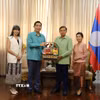 Đại sứ Phạm Việt Hùng (trái) và phu nhân trao lẵng quà tặng Đại sứ Lào Sisavath Inphachanh và phu nhân. (Ảnh: Đỗ Sinh/TTXVN)