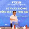 Phó Tổng Giám đốc TTXVN Nguyễn Tuấn Hùng ủng hộ đồng bào khắc phục hậu quả bão lũ. (Ảnh: Tuấn Anh/TTXVN)