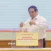 Thủ tướng Phạm Minh Chính quyên góp, ủng hộ đồng bào khắc phục hậu quả bão số 10. (Ảnh: Dương Giang/TTXVN)