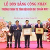 Ông Nguyễn Xuân Thắng trao Bằng công nhận đạt chuẩn mức độ 1 cho Ban Giám hiệu nhà trường. (Ảnh: Trung Kiên/TTXVN)