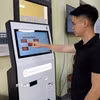 Người dân phường Mỹ Lâm (tỉnh Tuyên Quang) đăng ký thủ tục hành chính qua kiốt dịch vụ công. (Ảnh: Quang Cường/TTXVN)