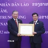 Tổng Bí thư, Chủ tịch nước Lào Thongloun Sisoulith trao tặng Huân chương Vàng Quốc gia của Nhà nước Lào cho Tổng Bí thư Tô Lâm. (Ảnh: Thống Nhất/TTXVN)