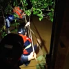 Lực lượng chức năng đu dây ra giữa dòng kênh để cứu người. (Ảnh: TTXVN phát)