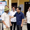 Bí thư Tỉnh ủy Bắc Ninh Nguyễn Anh Tuấn (áo xanh than) động viên người dân tại điểm lấy ý kiến đề án sáp nhập. (Ảnh: Thái Hùng/TTXVN)
