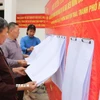 Người dân xem danh sách cử tri được niêm yết. (Ảnh: Mạnh Minh/TTXVN)