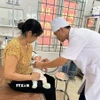Bác sỹ Trạm y tế Trung Nguyên, xã Tề Lỗ (Phú Thọ) khám cho bệnh nhi. (Ảnh: Nguyễn Thảo/TTXVN)