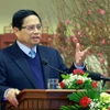 Thủ tướng Phạm Minh Chính chúc mừng năm mới Ất Tỵ ngành ngân hàng. (Ảnh: Dương Giang/TTXVN)