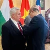 Đại sứ Việt Nam tại Hungary Bùi Lê Thái trao Huân chương Hữu nghị cho ông Váraljai Márton và ông Botz László. (Ảnh: TTXVN phát)