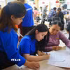 Thanh niên tình nguyện hỗ trợ người dân làm thủ tục hành chính tại phường Thanh Khê (thành phố Đà Nẵng). (Ảnh: Khoa Chương/TTXVN)