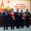 Chủ tịch Ủy ban Nhân dân thành phố Đà Nẵng Lê Trung Chinh (thứ hai từ trái sang) và Chủ tịch Ủy ban Mặt trận Tổ quốc Việt Nam thành phố Đà Nẵng Lê Văn Trung (thứ từ từ trái sang) nhận hoa chúc mừng của Thường trực Hội đồng Nhân dân thành phố Đà Nẵng. (Ảnh: Quốc Dũng/TTXVN)