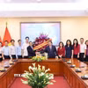 Phó Trưởng ban Thường trực Ban Tuyên giáo và Dân vận Trung ương Lại Xuân Môn tặng hoa chúc mừng những người làm báo của TTXVN. (Ảnh: Minh Đức/TTXVN)