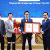 Ông Nguyễn Văn Được, Chủ tịch Ủy ban Nhân dân Thành phố Hồ Chí Minh trao Giấy chứng nhận đầu tư cho đại diện doanh nghiệp. (Ảnh: TTXVN phát)