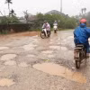 Đường dẫn lên cầu An Mô phía xã Triệu Long, huyện Triệu Phong còn dang dở, mặt đường nhiều vũng nước, trơn trượt, dẫn đến nguy cơ mất an toàn giao thông. (Ảnh: Nguyên Lý/TTXVN)